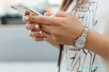picture of a woman's hands holding a phone with Spa Gregorie's logo in bottom right corner.