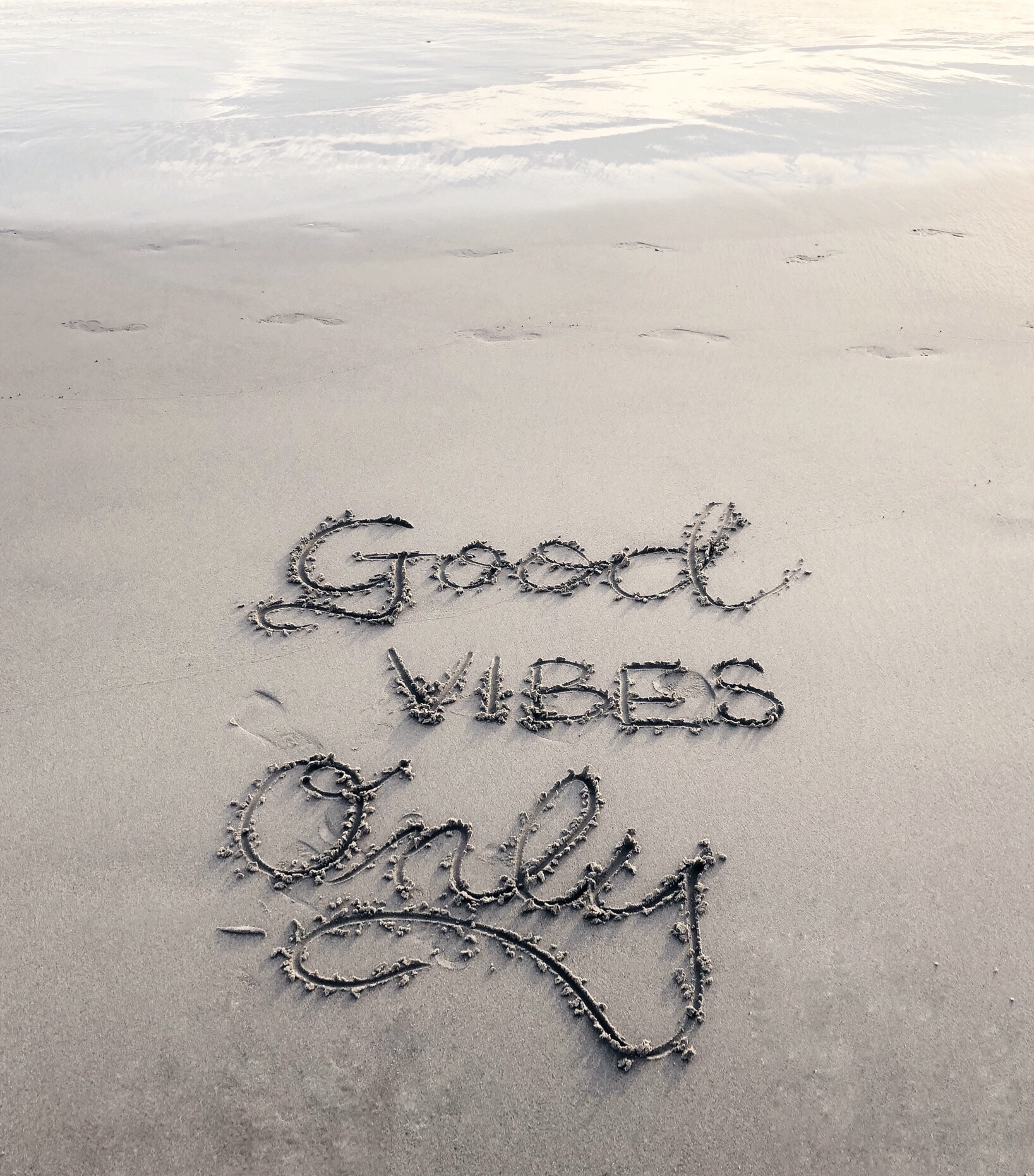 Good Vibes only written in beach sand
